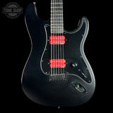 Black electric guitar with red pickups on a black background, featuring 'Tone Shop' logo.