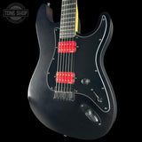 Black electric guitar with red pickups on a black background, featuring 'Tone Shop' logo.