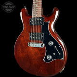 A classic double-cutaway electric guitar with a glossy reddish-brown sunburst finish, a black pickguard, and chrome hardware, shown against a solid black background.