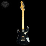 Black electric guitar with a visible brand logo on a black background