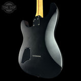 Black electric guitar with a visible brand logo on a black background