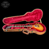 Gibson Les Paul guitar in a red-lined case with 'Tone Shop' logo.