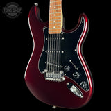 A close-up of a red metallic electric guitar body with a black pickguard, chrome hardware, and part of a light wood fretboard, shown against a black background with a Tone Shop watermark in the top left.