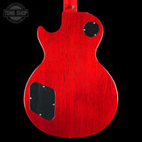 Red electric guitar body with a 'Tone Shop' logo in the corner.
