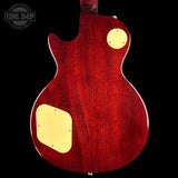 Close-up of a red electric guitar with a visible brand logo in the corner.