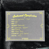 Instrument specification label on a guitar with black fur background