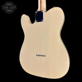 The back of a natural wood electric guitar body, likely a Fender Telecaster style, shown against a solid black background with a Tone Shop watermark in the top left corner.