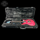 Red electric guitar in a black hard case with 'Tone Shop' logo.