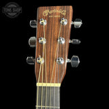 Close-up of a Martin guitar headstock with visible branding on a black background.