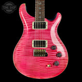 Pink electric guitar with a black background