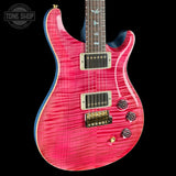 Pink electric guitar with a 'Tone Shop' logo in the corner