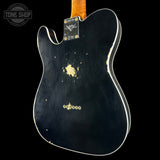 Black electric guitar body with visible wear on a black background, featuring the Fender logo.