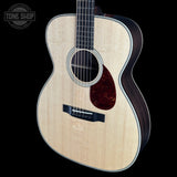 Acoustic guitar with a visible brand logo on a black background