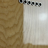 Six small silver metal cylindrical components with circular holes, arranged in a row on a light-colored wood-grain surface.