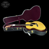Acoustic guitar in an open case with 'Tone Shop' branding.