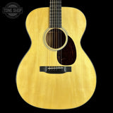 Acoustic guitar with a visible brand logo on a black background