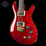 Red electric guitar with a black background, featuring the Tone Shop logo.