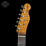 Close-up of a Fender Telecaster electric guitar headstock with six silver tuning pegs and a glossy brown wood finish, shown against a solid black background.