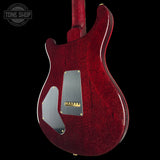 Red electric guitar with a visible brand logo on a black background