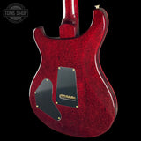 Red electric guitar body with a visible brand logo on a black background