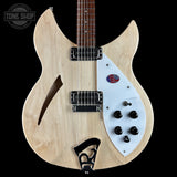 Electric guitar with a white pickguard and visible brand logo on a black background