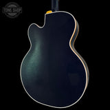 Guitar body with a glossy finish on a black background, featuring the Tone Shop logo.