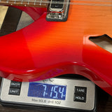 Red electric guitar on a digital scale displaying weight