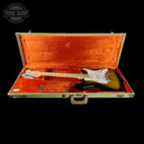 Electric guitar in an open case with 'Tone Shop' branding.