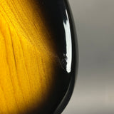Close-up of a guitar with a wooden neck and black body