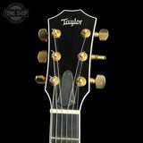 Taylor guitar headstock with tuning pegs on a black background