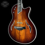 Wooden guitar with a flame pattern on a black background, featuring the Tone Shop logo.
