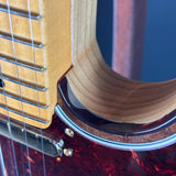 Close-up of a guitar's soundhole and strings with a blurred background