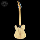 Wooden electric guitar with a visible brand logo on a black background