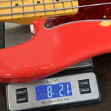 Red electric bass guitar on a digital scale displaying weight.