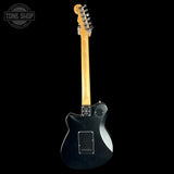 Black electric guitar with a visible brand logo on a black background