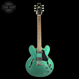 Turquoise electric guitar on a black background with 'Tone Shop' logo.