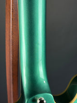 Close-up of a green and brown skateboard deck with a blurred background