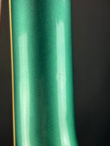 Close-up of a green metallic object with a dark background