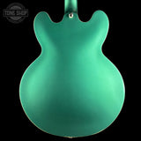 Green electric guitar body with 'Tone Shop' logo in the corner