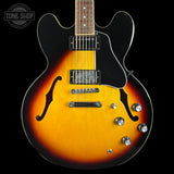 Electric guitar with a sunburst finish on a black background, featuring the Tone Shop logo.
