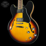 Electric guitar with a sunburst finish on a black background, featuring the Tone Shop logo.