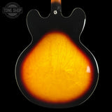 Close-up of a guitar's sunburst finish with 'Tone Shop' logo.