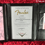 Fender certificate of authenticity in a black case on a red textured surface
