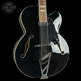 Black and silver electric guitar on a black background with 'Tone Shop' logo.