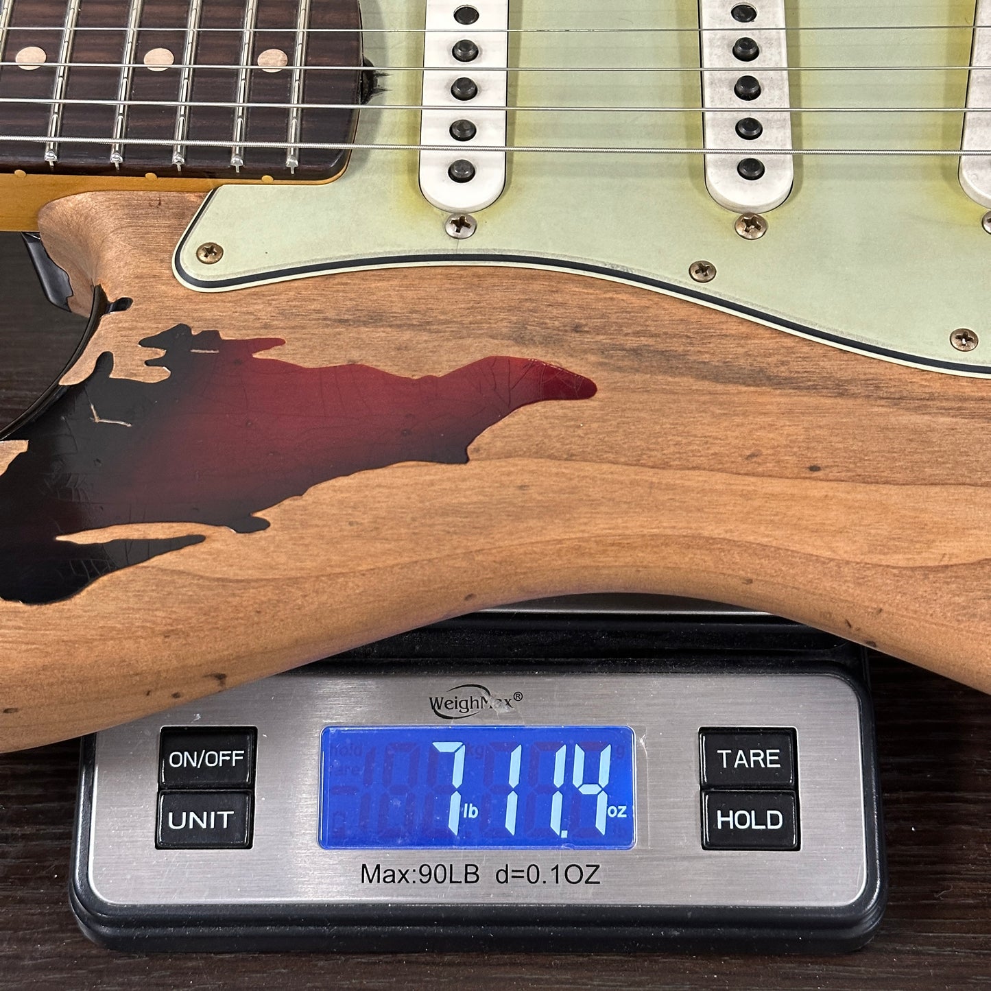 Electric guitar on a digital scale displaying weight