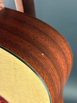 Close-up of a guitar's wooden neck and tortoiseshell binding against a gray background