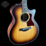 Acoustic guitar with a sunburst finish on a black background, featuring the Tone Shop logo.
