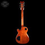 Wooden electric guitar on a black background with 'Tone Shop' logo.
