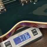 Digital scale displaying weight of a guitar on a wooden surface
