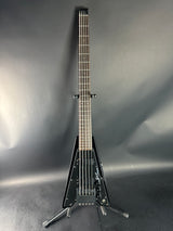Black electric guitar on a gray surface